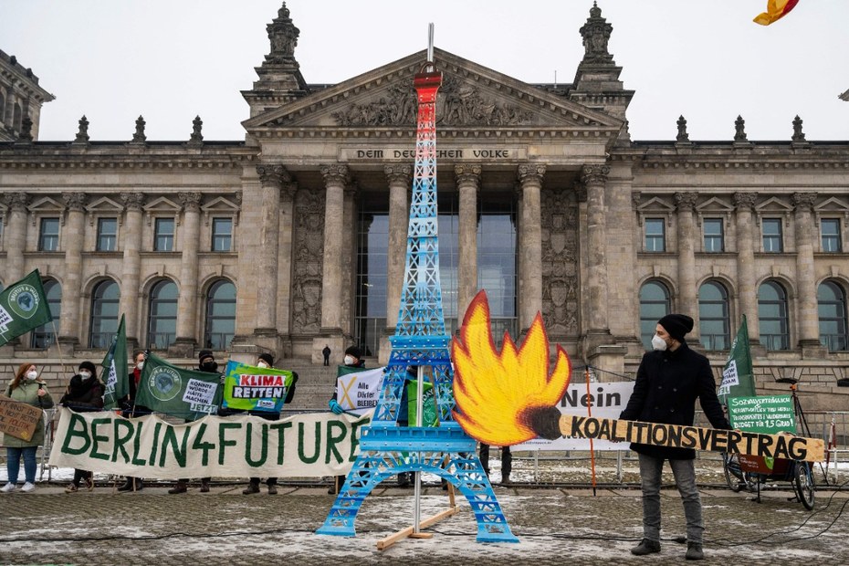 Demonstrant: innen protestieren gegen den Koalitionsvertrag von SPD, Grüne und FDP.  Als Symbol für das Pariser-Abkommen aus dem Jahr 2015 steht eine Miniaturversion des Eifelturms vor dem Reichstag.