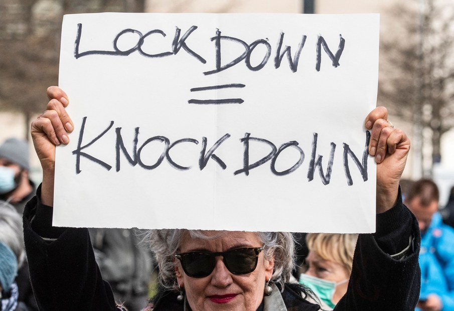Demonstrantin mit einem „Lockdown = Knockdown“-Schild auf einem Protest im April 2021.