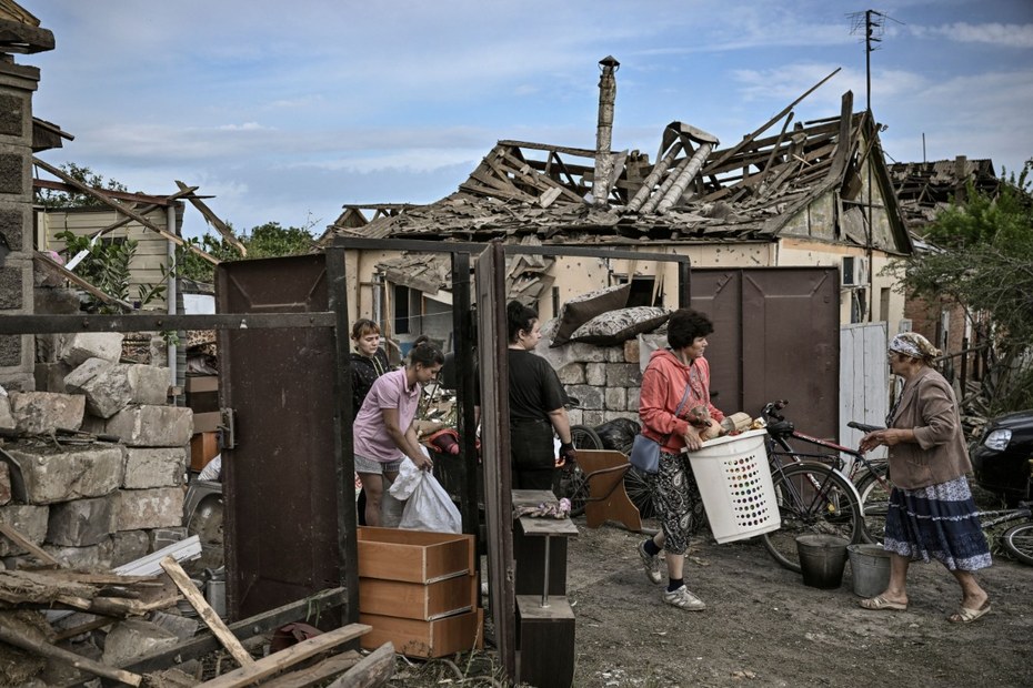 Nach einem russischen Angriff auf ein Wohnhaus in Druzhkovka bergen ukrainische Anwohner*innen ihre Besitztümer aus den Trümmern.