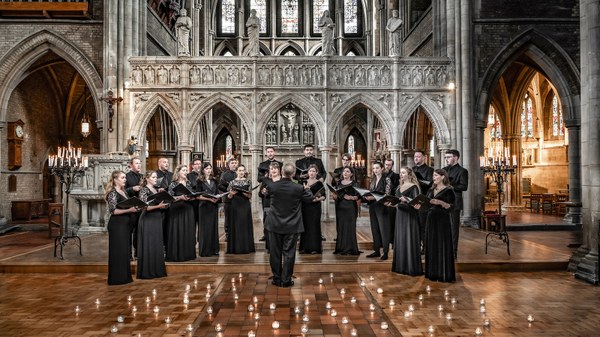 Ein Kammerchor steht vor einer Orgel und singt.