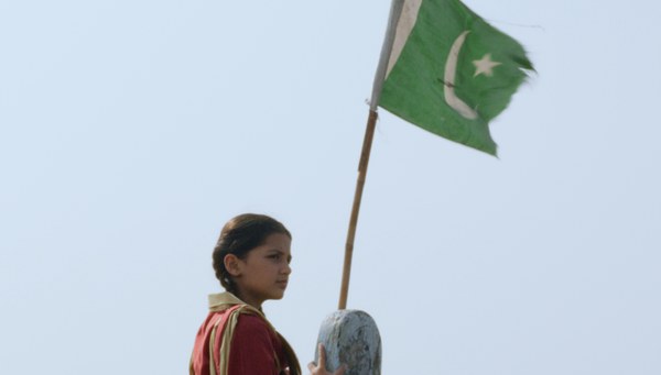 Die Schülerin Rabia steht an einer pakistanischen Flagge.