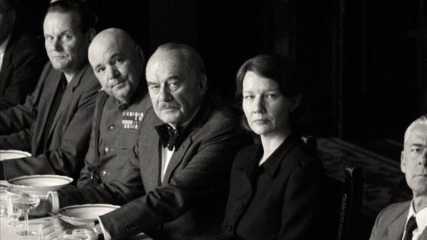 Thomas (Hanns Zischler) und Erika Mann (Sandra Hüller) sitzen in einer Reihe am Esstisch mit anderen Männern.